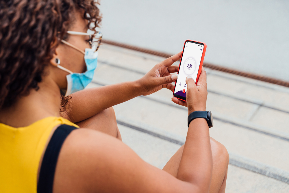 Over-the-shoulder view of a woman using a cell phone