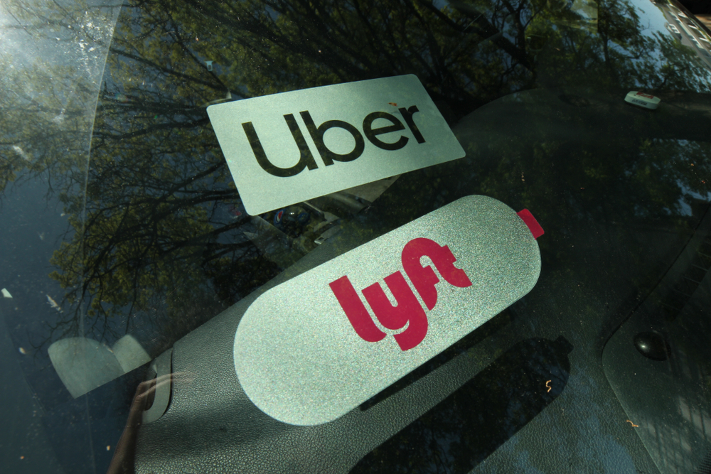 Uber and Lyft rideshare tags in front windshield of car