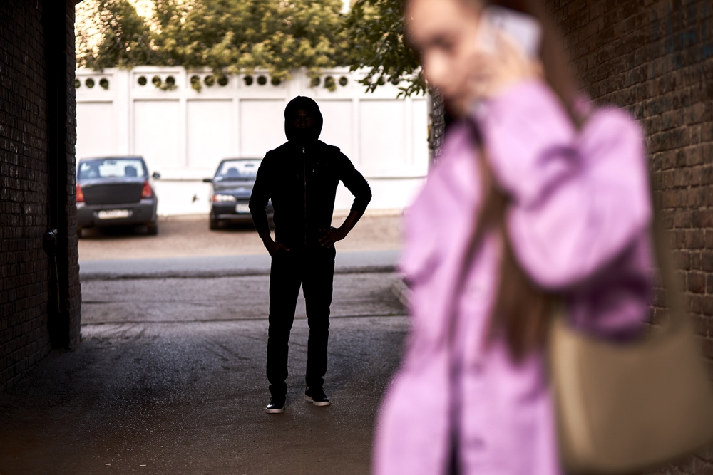 Woman walking past a stranger in an unmonitored alley